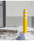 Straight Up Heavy Duty Removable Safety Bollard With Three Reflective Stripes For Driveway And Parking Lot Vehicle Control in snow near a building.