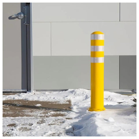 Straight Up Heavy Duty Removable Safety Bollard With Three Reflective Stripes For Driveway And Parking Lot Vehicle Control in snow near a building.