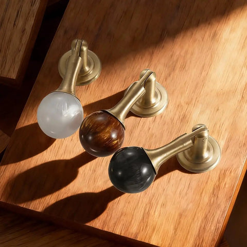 Three Two Pack Brass Cabinet Pulls With Copper Base Tear Drop Knobs For Kitchen Cabinets Dressers Closets And Cupboards on wood surface