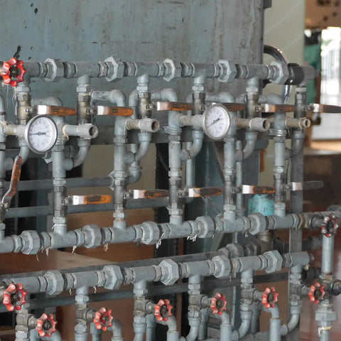 Complex piping system with gauges and red valves, not related to Twenty Pack Three Quarter Inch NPT PVC Liquid Tight Conduit Connectors.