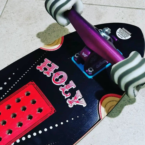 Close-up of skateboard with colorful design, featuring mounted white wheels. California Roll 60mm 78A White Skateboard Longboard Wheels visible.