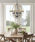 Harmon 27 Inch Six Light Dope Modern Farmhouse Armillary Chandelier With Sphere Globe Design In Smoked Birch Finish hanging over dining table