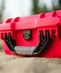 Close-up of Mini Pro Waterproof First Aid Kit for Car, Home, Boat, Camping and Travel, featuring rugged red case with handle.
