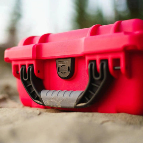 Close-up of Mini Pro Waterproof First Aid Kit for Car, Home, Boat, Camping and Travel, featuring rugged red case with handle.
