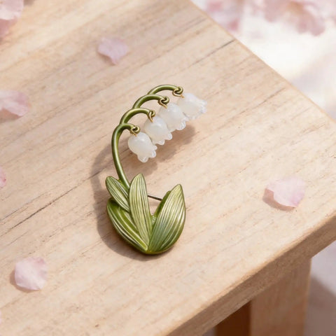 Delicate Lily Of The Valley Brooch For Women Featuring Tiny Bell Shaped Petals Lightweight Floral Pin on wooden surface.