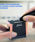 Close-up of hands using tweezers to customize characters on a Badass DIY Self Ink Stamp Kit with dual alphabet sets.