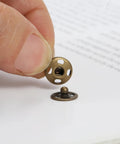 Close-up of a copper snap button from the Two Hundred Pcs Fabric Snaps Set in 8mm and 10mm Sizes with Five Color Options.