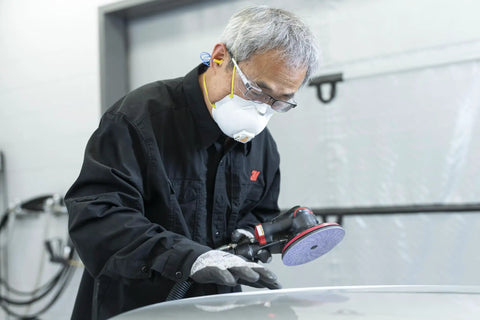 Kick Some Serious Grit With These 3M Cubitron II Hookit Abrasive Discs For Auto Work. User sanding car hood with a power tool.