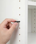Hand installing 24 Pack Shelf Support Pins For Cabinets And Storage Shelves Carbon Steel With Rubber Caps No Fuss Easy Install
