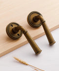 Antique Brass Passage Door Handle Lever For Interior Doors Vintage Aluminum Alloy Door Lever For Hall Closet Kitchen Pantry No Locking Required Easy Install 1 Pack, close-up view of two levers against wooden background.