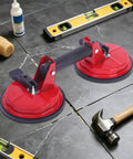 Professional Grade Heavy Duty Double Claw Vacuum Suction Cup Lifter Handles Glass Tile Wall Panel And Car Windshield Featuring Hella Strong Suction Force on tiles with hammer and level.