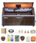 Creality Falcon A1 laser engraver with enclosed gray chassis and orange lid; front window and sample materials.