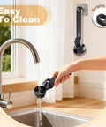 Mess Free Two Tablespoon Coffee Scoop With Built In Funnel For Reusable K Cup Pods being rinsed under a tap with hanging hole.