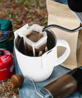 Go To Portable Coffee Filter Bags With Hanging Ear Design in use over white cup during camping