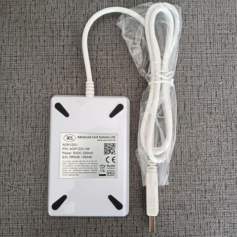 ACR122U NFC Reader Writer Kit with USB cable on gray surface, part of product NFC Reader Writer Kit ACR122U With 5 NTAG213 Tags And 2 UID MF1 Cards Plus Free Software SDK For Windows Mac Linux 13.56 Megahertz Card Access Tool Supports MIFARE Ultralight Plus DesFire ISO 14443 A