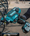 Makita 18 Volt Cordless Automatic Rebar Tying Tool With Makpac Case held by a worker, designed for concrete construction, showing detailed grip.