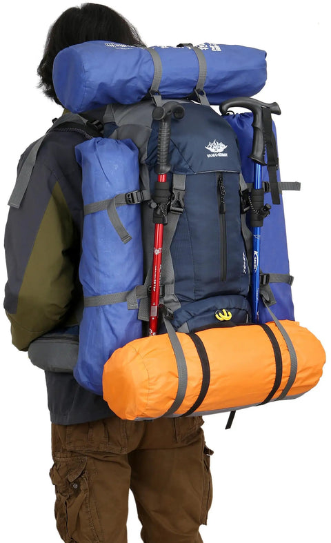 Person carrying 50L Waterproof Hiking Backpack With Rain Cover For Outdoor Adventures, loaded with sleeping gear and poles