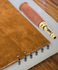 Heavy Duty Brass Leather Hole Punch With A Comfy Wooden Handle with drill bits on leather for crafting and DIY use.