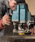 Carpenter using router with Router Bits Set 50 Piece, One Quarter Inch Shank, Tungsten Carbide Bits For Woodworking.