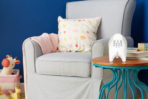 Baby Soother Night Light Moonlight Melodies With Projection And Music Plug In Dimmable Warm Glow on side table in nursery.