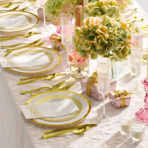 Heavy Duty White Plastic Plates With Gold Trim 175 Piece Bulk Party Essentials set up on a decorated table with silverware and flowers.