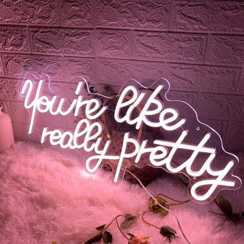 You Are Like Really Pretty Neon Light Sign Peach Pink LED Neon Wall Decor glowing on a fluffy surface in a cozy room setting.