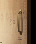 Six Pack Antique Brass Arch Cabinet Pulls, 5-Inch Center-To-Center Zinc Alloy Drawer Handles For Kitchen And Bathroom Cupboards, Mid-Century Modern Hardware shown in side view on wood surface