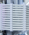Close-up of white 24 Pack PSU Wire Management Clips Kit for ATX Power Cables organizing cables, fits 3mm to 3.5mm gauge.