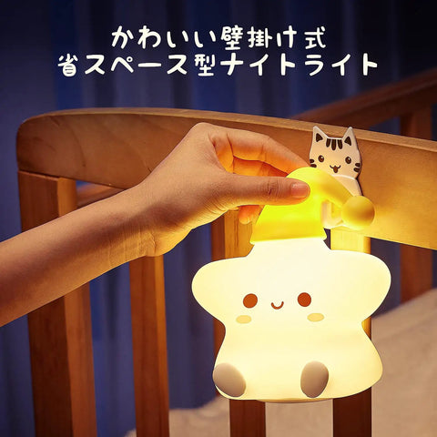 Hand holding Cute Stars Night Light For Baby Nursery on crib, Color Changing Silicone Star Lamp, Rechargeable Kids Room Decor.