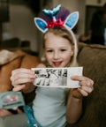 Instant Print Paper Refill Set For Kids Camera 57mm Wide Thermal Paper Rolls 2.25 Inch BPA Free Includes 3 Regular Rolls And 2 Adhesive Rolls For Easy Snap Prints Up To 300 Photos; child holding printed photo