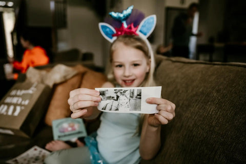 Instant Print Paper Refill Set For Kids Camera 57mm Wide Thermal Paper Rolls 2.25 Inch BPA Free Includes 3 Regular Rolls And 2 Adhesive Rolls For Easy Snap Prints Up To 300 Photos; child holding printed photo