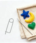 Heavy Duty Stainless Steel Locking Clamp Pins For Machinery Automotive Aerospace on a knit fabric with colorful felt shapes.