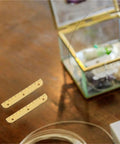 Two small hidden piano hinges on wooden table, part of Ten Pack Small Hidden Piano Hinges For Wooden Boxes And Jewelry Chests kit.