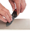 Hands sharpening knife on 8 Inch Diamond Sharpening And Flattening Stone Double Sided 180/600 Grit Bench Stone in home shop.