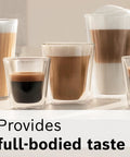 Set of five clear glass coffee cups on a light kitchen counter with layered espresso drinks and milk foam.