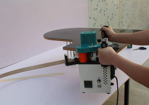 User operating Pro Grade Woodworking Edge Bander Banding Machine with adjustable temperature and speed on wooden panel.
