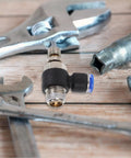 Super Easy 12 Piece Air Hose Adapter Fitting Kit With Abs And Copper Push To Connect Pneumatic Joints For Any Air Compressor Time Saving Install And Quick Release Couplers That Replace Old Broken Fittings Fast And Reliable black push-to-connect air hose adapter with wrench ends on wood