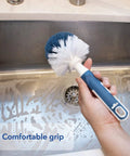Heavy Duty Sink And Dish Scrub Brush With Safe Bristles, Perfect For Pots And Pans, Knocks Stubborn Food Right Off, Super Handy Kitchen Cleaning Tool That Handles Drains Like A Champ in hand over a soapy sink.