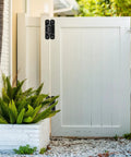 Rock Solid 6.7 Inch Heavy Duty Gate Hinges Built Tough for Daily Grind on white wooden gate with greenery.