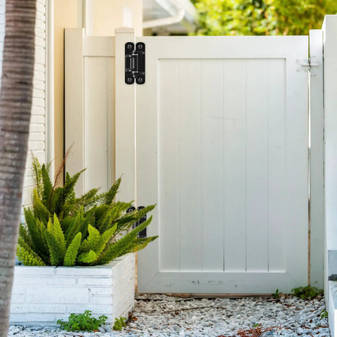 Rock Solid 6.7 Inch Heavy Duty Gate Hinges Built Tough for Daily Grind on white wooden gate with greenery.