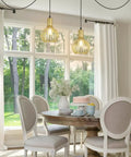 Black Pendant Light With Vintage Industrial Vibe hanging over a dining table in a bright room with white curtains and large windows.
