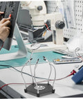 Helping Hands Soldering Tool With LED Magnifying Lamp And Adjustable Arms on a workbench during circuit board repair.