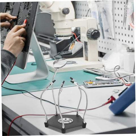 Helping Hands Soldering Tool With LED Magnifying Lamp And Adjustable Arms on a workbench during circuit board repair.