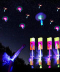Child playing with 60 Pack LED Arrow Helicopter Slingshot Toys For Kids, Electric LED Flying Copters illuminating night sky.