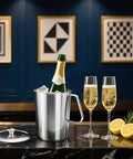 Barista Grade Stainless Steel Pitcher With Lid 79oz 2.3L on bar top with champagne bottle and glasses