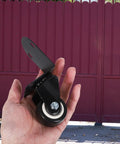 Hand holding a Two Pack 2 Inch Universal Silent Swivel Plate Caster for Furniture Cabinets and Drawers, showing black wheel and plate.