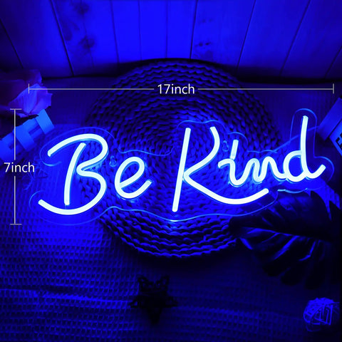 Blue 'Be Kind' neon sign, 17x7 inches, glowing on a textured background with leaves visible, neon wall decor with bright blue light