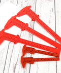 Depth Vernier Caliper Micrometer Gauge Measuring Tool, Multifunctional Depth Caliper in red plastic on wooden surface.