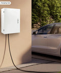 Built Like A Tank Wall Mounted EV Charger Armor Box With Combo Lock Cable Management Tray For Garage Outdoor Install Weather Resistant Cover To Keep Your Rig Safe From Storms, mounted on wall next to electric vehicle.