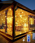 Solar Curtain Lights For Outdoors 2 Pack 300 LED Fairy String Lights adorn a gazebo with warm white glow, remote and solar panel visible